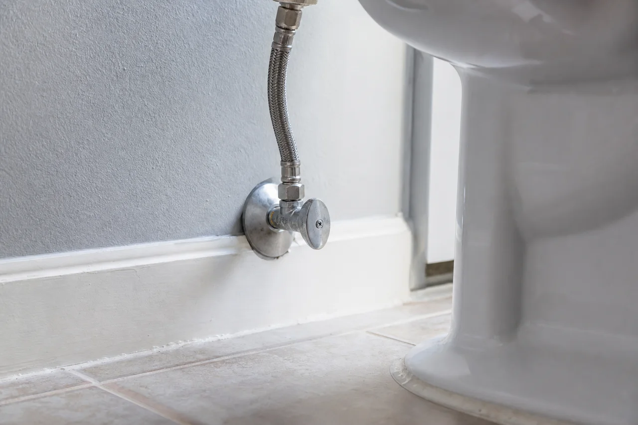 Toilet supply shutoff and connection illustrating a monthly plumbing inspection